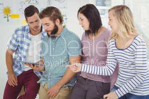 Business people discussing while using digital tablet