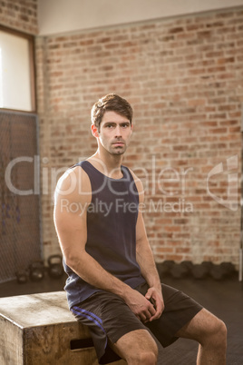 Portrait of man sitting on plyo box