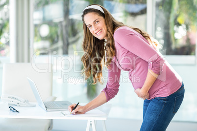 Portrait of businesswoman writing note
