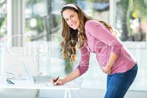 Portrait of businesswoman writing note