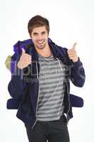 Portrait of happy man with backpack showing thumbs up