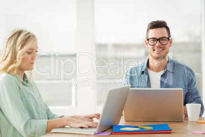Portrait of happy man wearing eyeglasses with woman working on l