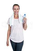 Portrait of happy sporty woman holding bottle