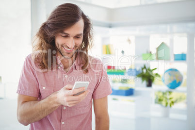 Hipster smiling while looking at mobile phone