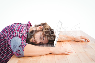Hipster napping with head on laptop