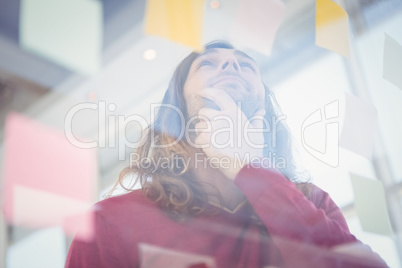 Low angle view of thoughtful hipster looking at sticky note