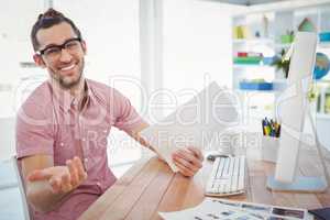 Happy businessman gesturing while holding documents