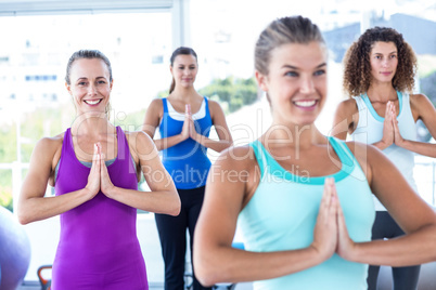 Women smiling in fitness studio with hands together