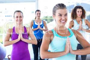 Women smiling in fitness studio with hands together