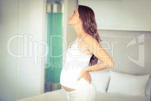 Side view of pregnant woman standing in bedroom