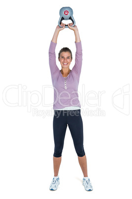 Portrait of happy young woman exercising with kettlebell