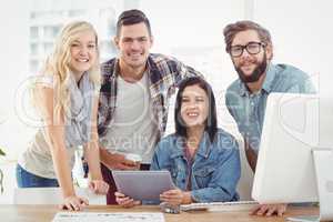 Portrait of smiling business professionals using digital tablet