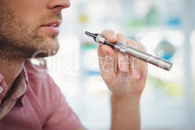 Cropped image of man smoking electronic cigarette