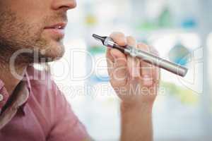Cropped image of man smoking electronic cigarette