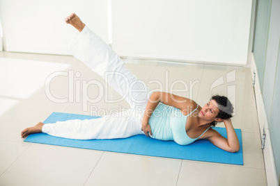 Focused pregnant woman exercising at home