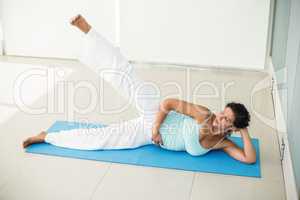 Focused pregnant woman exercising at home