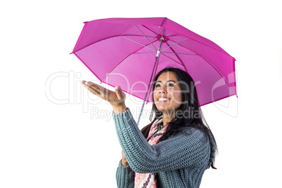 Woman checking the weather from under her umbrella