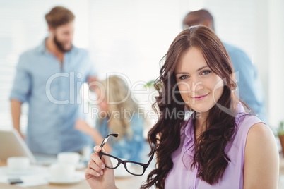 Portrait of smiling woman holding eyeglasses