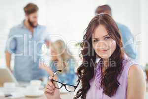 Portrait of smiling woman holding eyeglasses