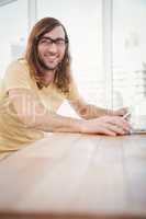 Happy hipster wearing eye glasses working at desk