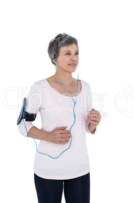 Mature woman listening music while jogging