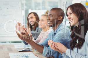 Smiling business people clapping at desk