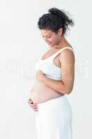 Smiling pregnant woman touching tummy