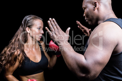 Trainer instructing female boxer