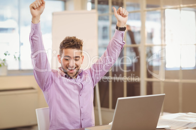 Happy businessman with arms raised