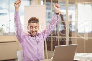 Happy businessman with arms raised