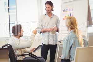 Disabled businessman pointing towards whiteboard