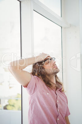 Tired hipster standing with hand on head