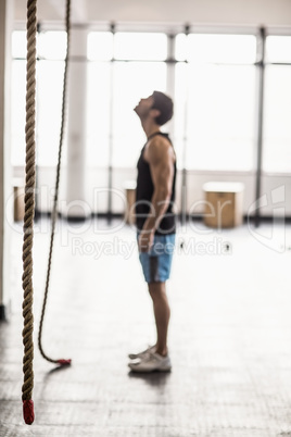Young bodybuilder looking at the ropes