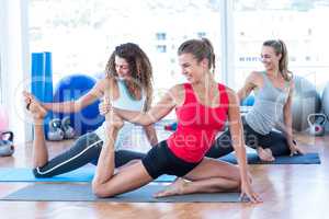 Happy women doing pigeon pose with one hand right leg grab