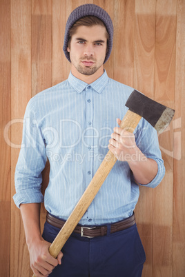 Portrait of serious hipster holding axe