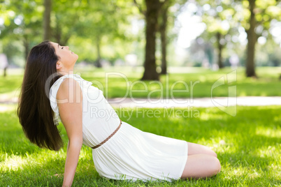 Side view of young woman relaxing on grassland