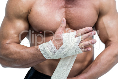 Midsection of fighter tying bandage on hand