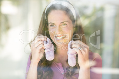 Portrait of happy woman with baby shoes