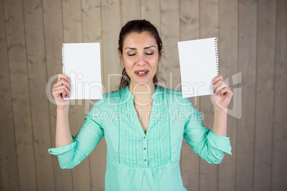 Smiling woman with eyes closed while holding papers