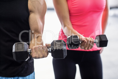 Sporty couple exercising with dumbbells i