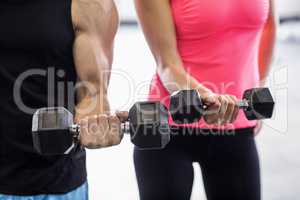 Sporty couple exercising with dumbbells i