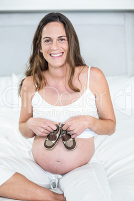 Portrait of happy woman with boots on belly