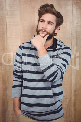 Thoughtful hipster with hand on chin