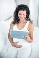 Attractive pregnant woman using digital tablet