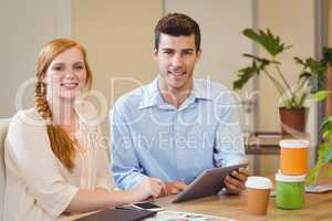 Business people using digital tablet at desk