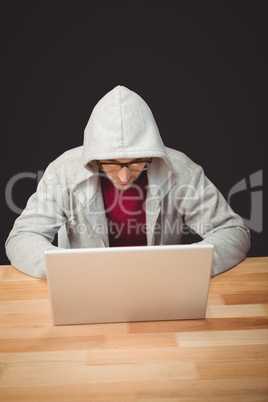 Man with hooded shirt working on laptop