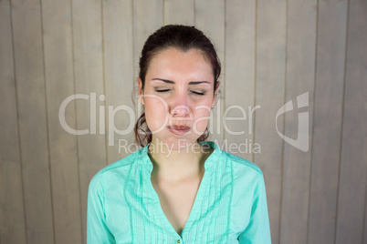 Woman with eyes closed while making face