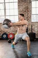 Muscular man exercising with medicine ball