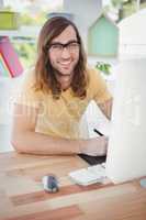 Portrait of happy hipster at computer desk