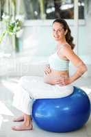 Portrait of happy woman sitting on exercise ball